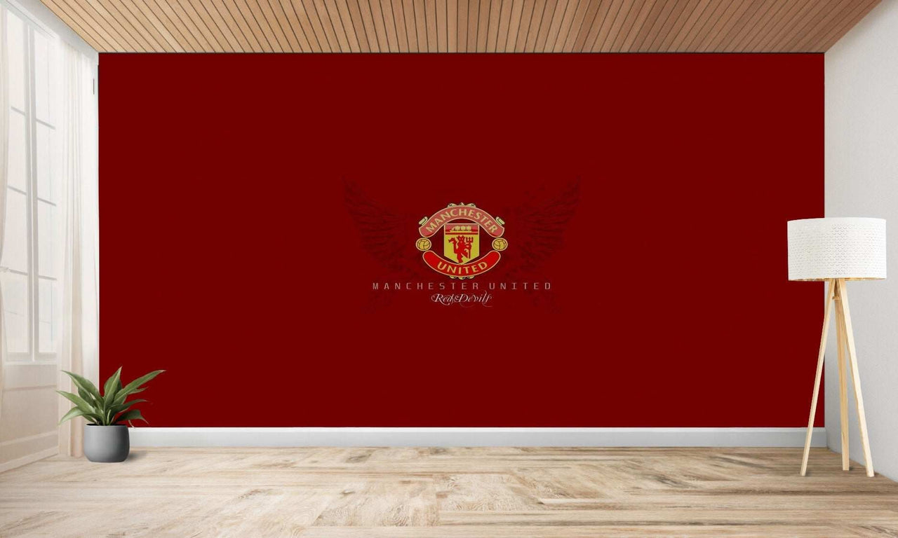 Logo de Manchester United sur un mur rouge.