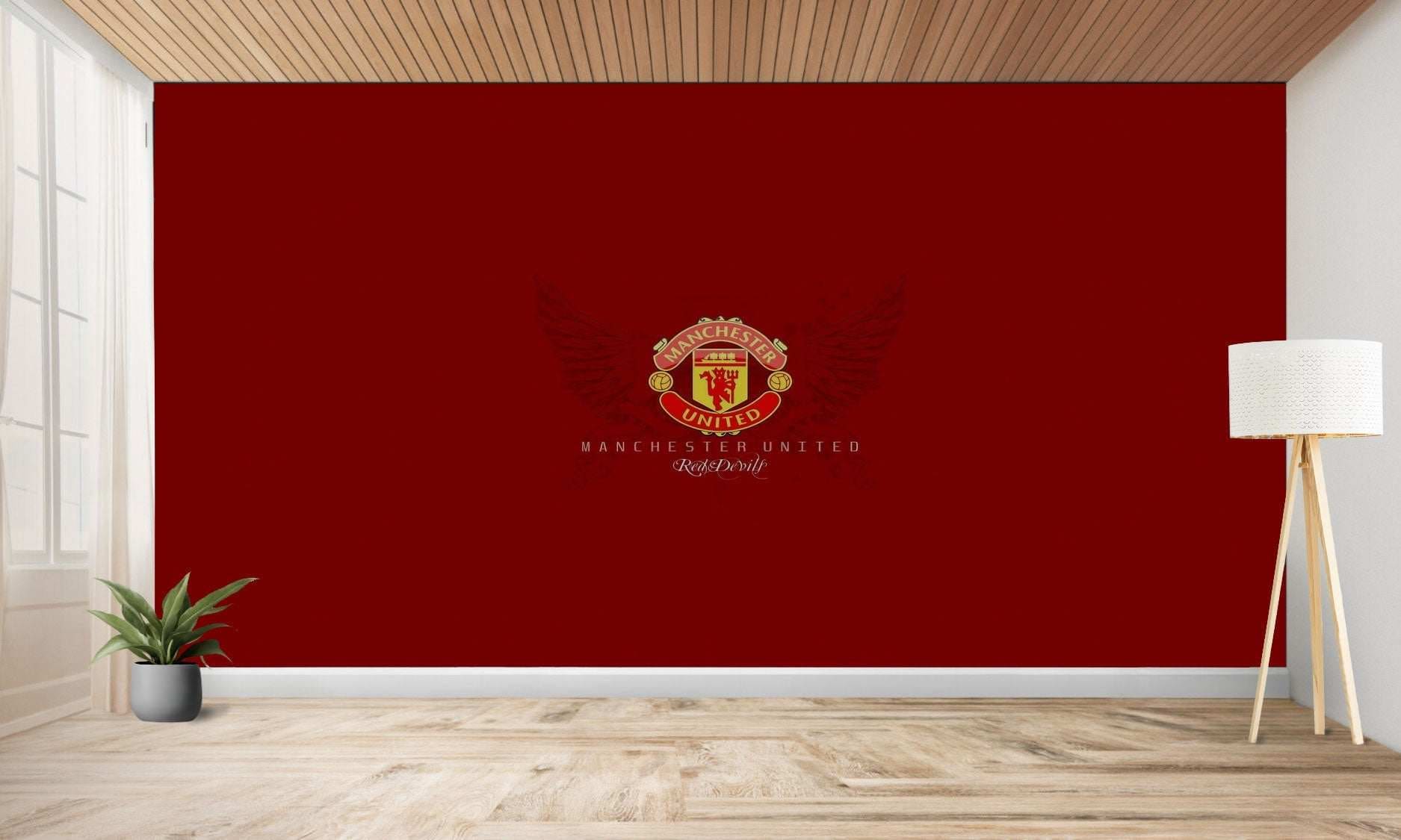 Logo de Manchester United sur un mur rouge.